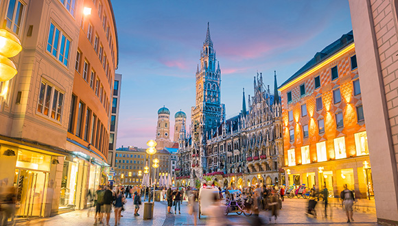 German skyline at night with people walking in a town squre